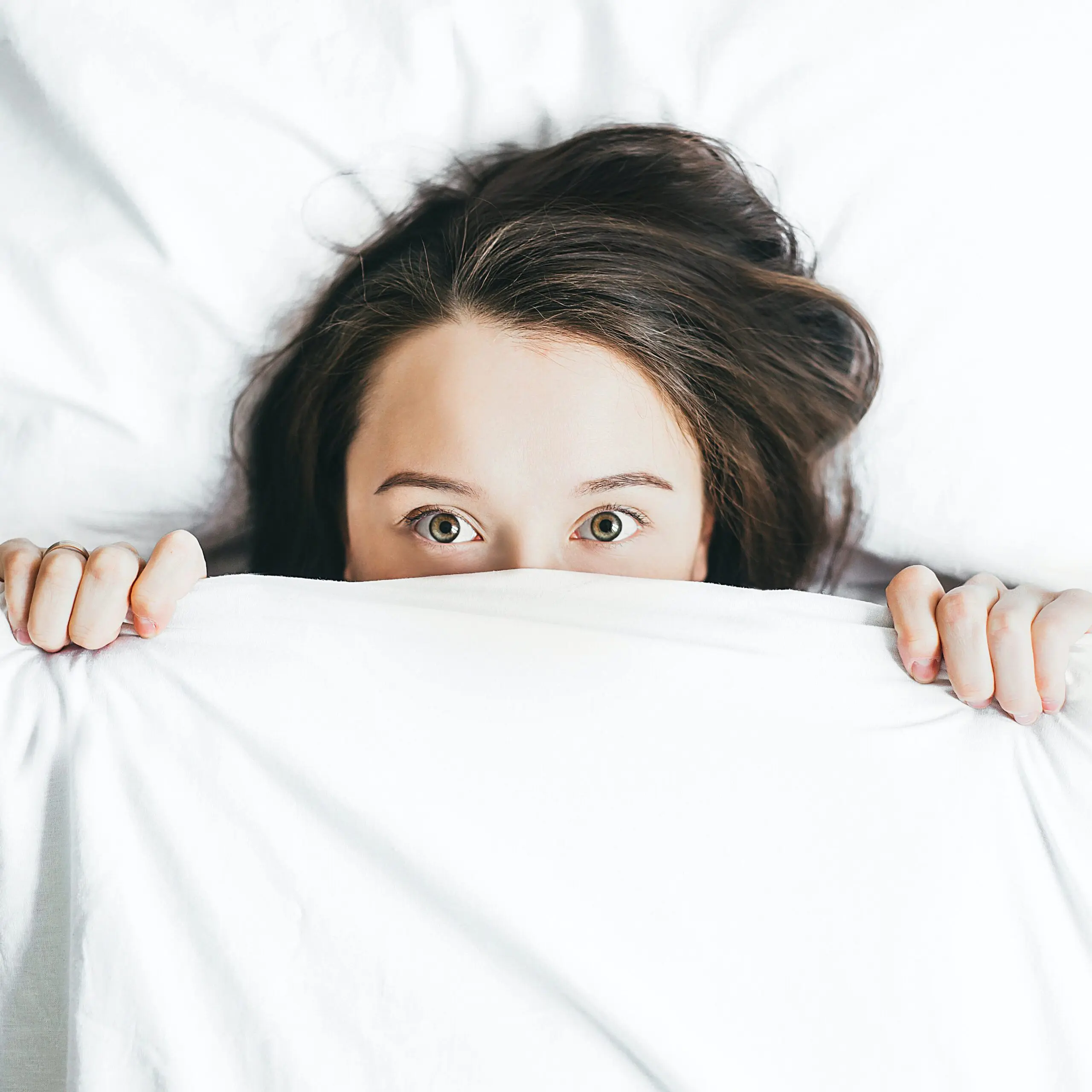 woman in the bed, covering the face with duvet